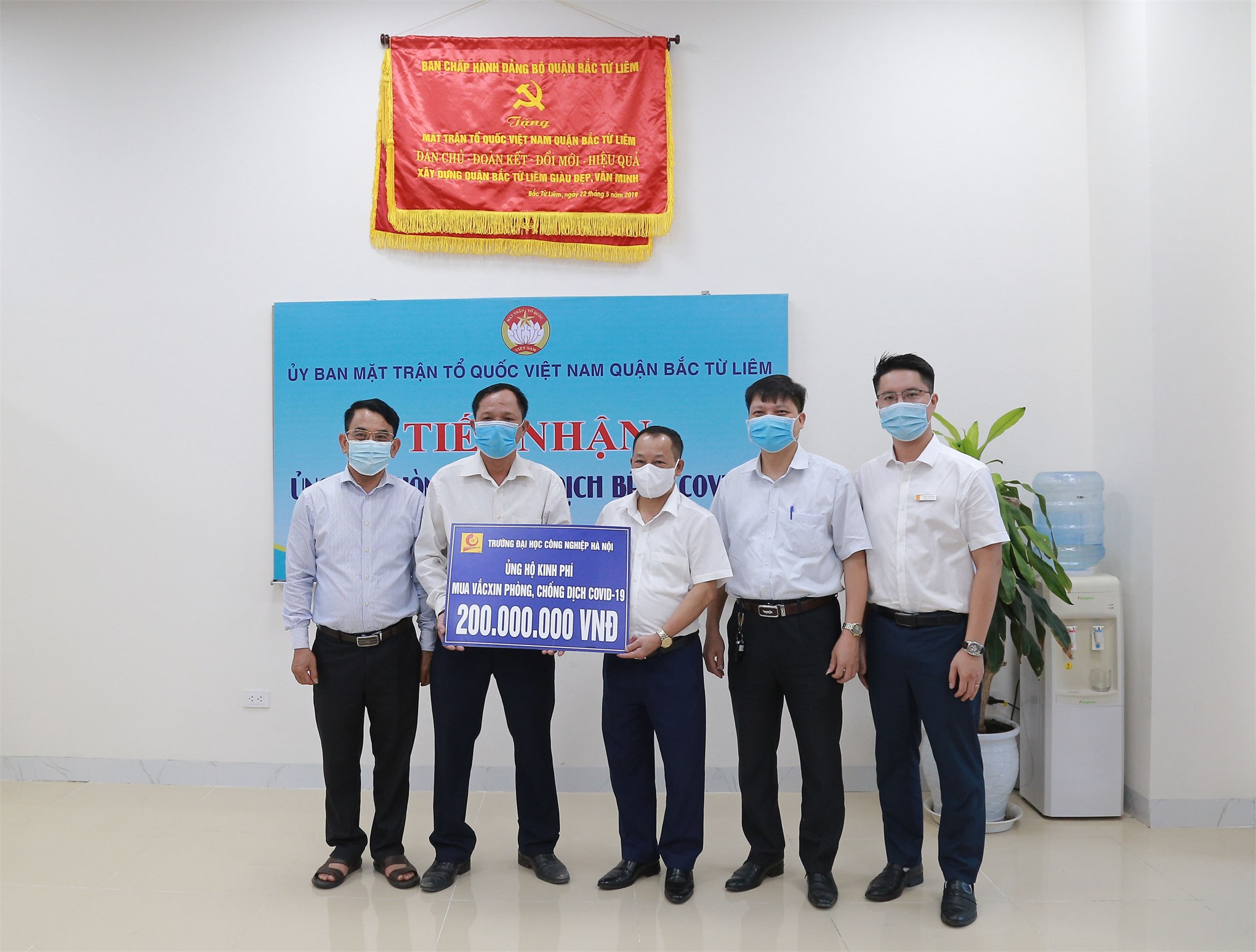 Dr. Nguyen Anh Tuan - Vice-Rector (in the center) symbolically donated to the Vietnam Fatherland Front Committee of Bac Tu Liem district. According to Dr. Nguyen Anh Tuan, in recent days, the situation of the COVID-19 pandemic has been complicated across the country. HaUI wishes to share with the community, to realize the 